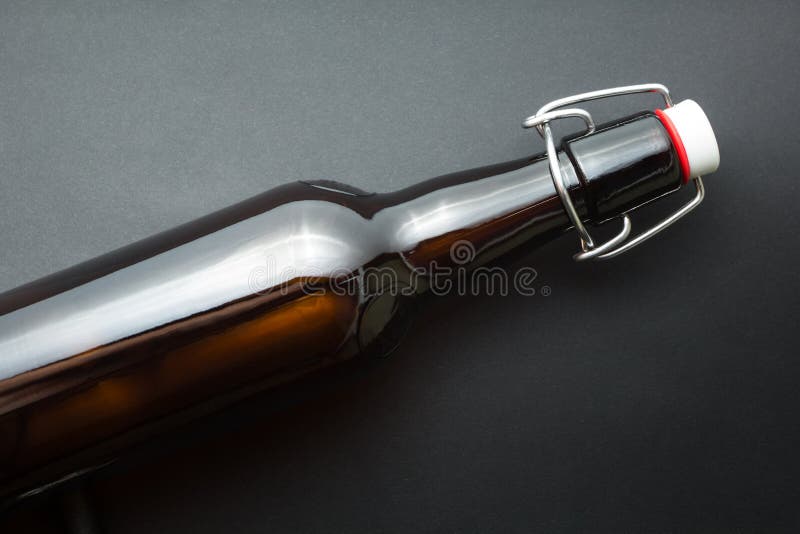 Vecchia bottiglia marrone di birra isolata su fondo nero immagini stock Vecchia bottiglia marrone di birra isolata su fondo nero immagini stock