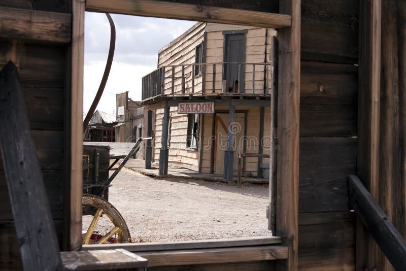Looking at the Old West town saloon through the window of an abandoned hotel building. Looking at the Old West town saloon through the window of an abandoned hotel building