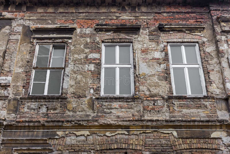 Vecchia costruzione abbandonata con tre finestre Muro di mattoni invecchiato Concetto d'annata di architettura Casa antica fotografia stock libera da diritti Vecchia costruzione abbandonata con tre finestre Muro di mattoni invecchiato Concetto d'annata di architettura Casa antica fotografia stock libera da diritti