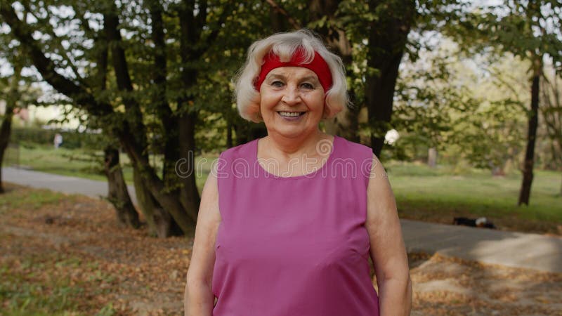 Senior old runner woman in city park enjoying healthy active lifestyle. Elderly female working out cardio morning exercise outdoor. Active sport people. Senior old runner woman in city park enjoying healthy active lifestyle. Elderly female working out cardio morning exercise outdoor. Active sport people