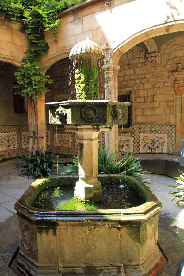 Vecchia fontana di pietra nel cortile della chiesa a Barcellona, Spagna fotografie stock