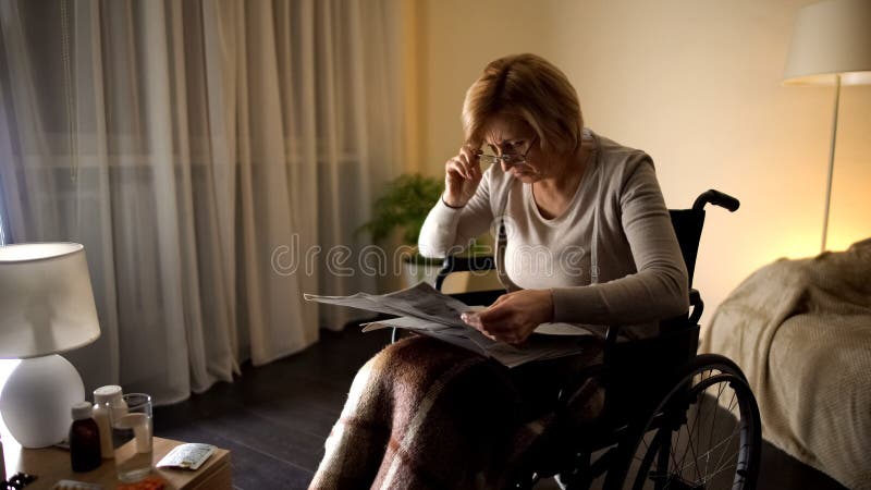 Vecchia prova femminile di leggere giornale in occhiali, problema dell'occhio, offuscamento della vista fotografia stock Vecchia prova femminile di leggere giornale in occhiali, problema dell'occhio, offuscamento della vista fotografia stock