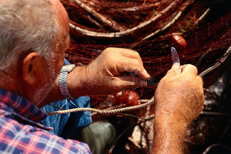 Vecchia rete di riparazione del pescatore immagini stock Vecchia rete di riparazione del pescatore immagini stock