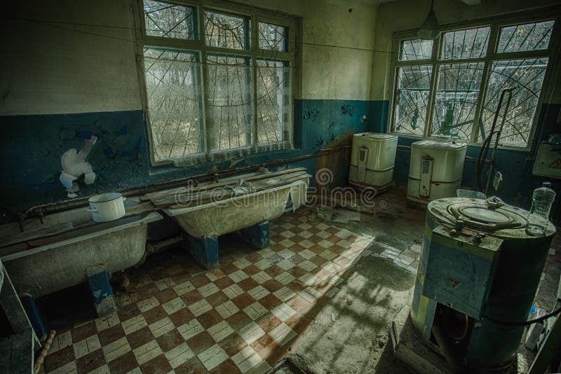 Vecchia stanza di lavanderia sinistra e terrificante in un ospedale psichiatrico abbandonato fotografia stock libera da diritti Vecchia stanza di lavanderia sinistra e terrificante in un ospedale psichiatrico abbandonato fotografia stock libera da diritti