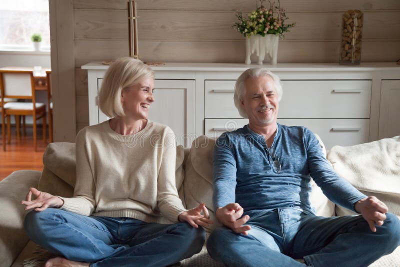 Vecchie coppie divertendosi risata facendo yoga insieme a casa immagini stock libere da diritti Vecchie coppie divertendosi risata facendo yoga insieme a casa immagini stock libere da diritti