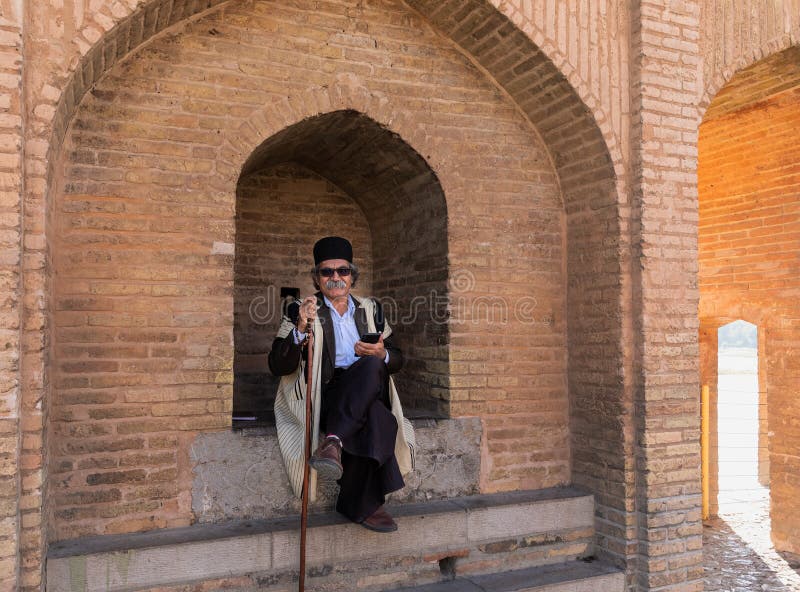 Isfahan, Iran - November 2, 2019: Local old man on Si-o-Se Pol (Bridge of 33 Arches or Allahverdi Khan Bridge) on Zayanderud in Isfahan, Iran. Architectural masterpiece and heritage. Isfahan, Iran - November 2, 2019: Local old man on Si-o-Se Pol (Bridge of 33 Arches or Allahverdi Khan Bridge) on Zayanderud in Isfahan, Iran. Architectural masterpiece and heritage.