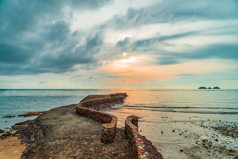 Vecchio molo della roccia del birck vicino alla linea costiera al tramonto fotografia stock Vecchio molo della roccia del birck vicino alla linea costiera al tramonto fotografia stock