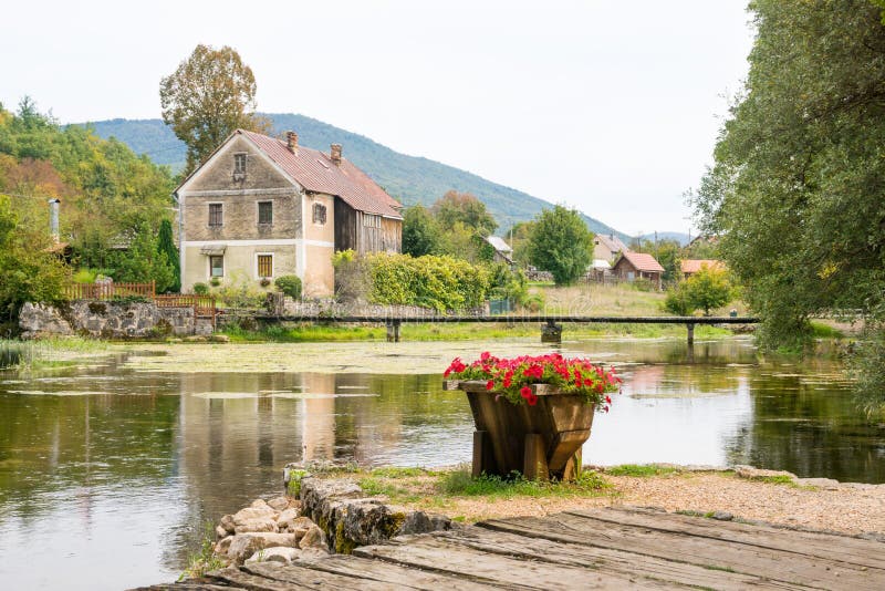 Vecchio mulino di legno idilliaco al fiume di gacka in Croazia centrale immagine stock libera da diritti Vecchio mulino di legno idilliaco al fiume di gacka in Croazia centrale immagine stock libera da diritti