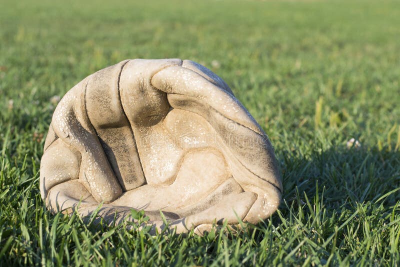Vecchio pallone da calcio sgonfiato sull'erba del campo di calcio immagine stock Vecchio pallone da calcio sgonfiato sull'erba del campo di calcio immagine stock