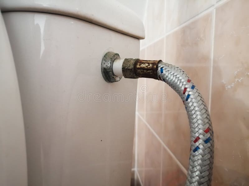 rusty old toilet hose in the bathroomn. rusty old toilet hose in the bathroomn