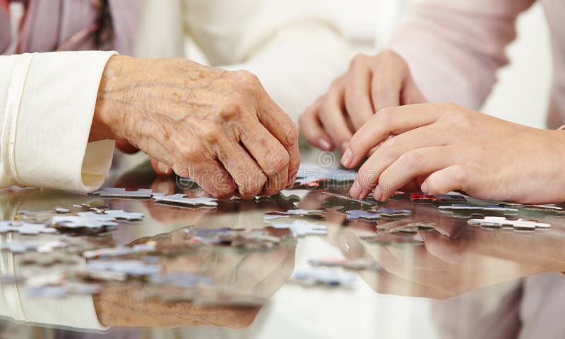 Vechi mâini rezolvând puzzle-ul royalty free stock photos