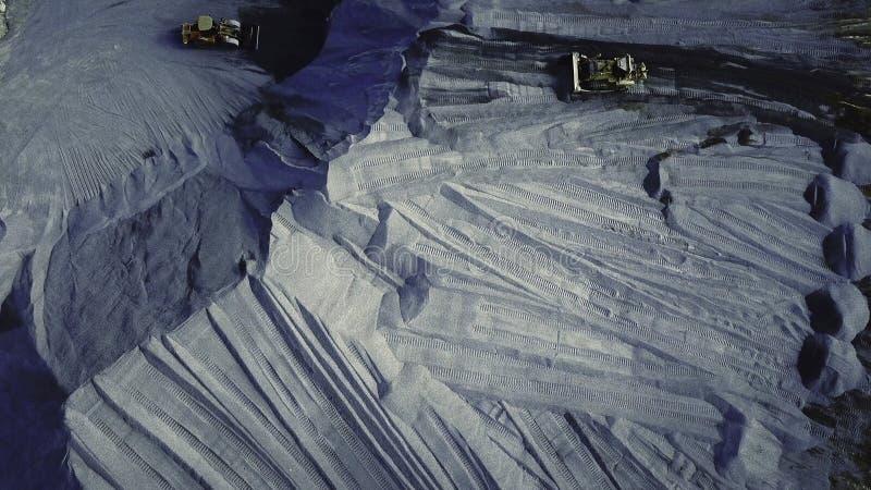 Vedere aeriană a carierei în care se desfășoară activități de excavatoare și camioane în industria grea și conceptul de extracție stock images