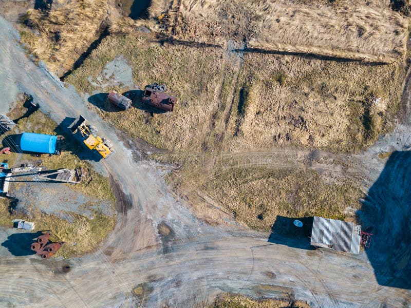 Vedere aeriană a unui excavator și a unui tractor galben care transportă ciment sfărâmat și nisip în timpul extracției mineralelor stock image