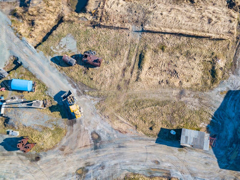 Vedere aeriană a unui excavator și a unui tractor galben care transportă ciment sfărâmat și nisip în timpul extracției mineralelor stock photography