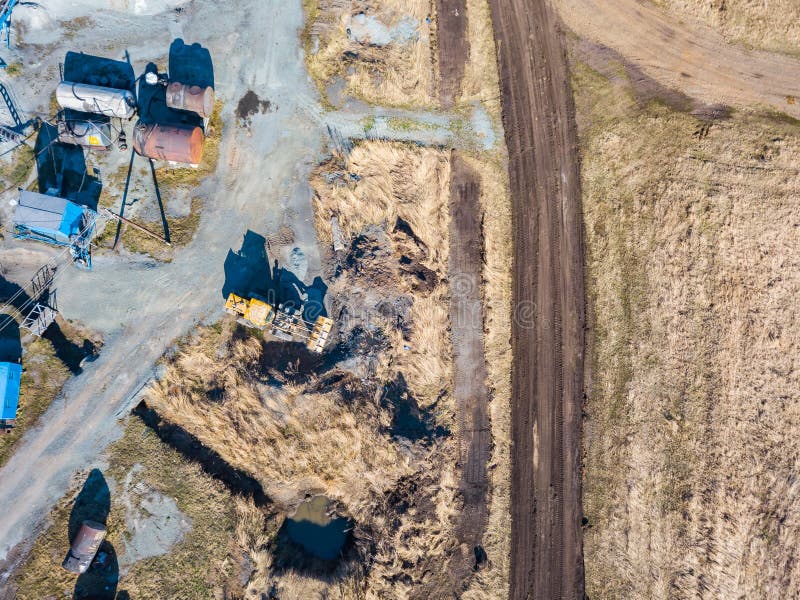 Vedere aeriană a unui excavator și a unui tractor galben care transportă ciment sfărâmat și nisip în timpul extracției mineralelor royalty free stock image