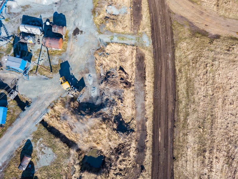 Vedere aeriană a unui excavator și a unui tractor galben care transportă ciment sfărâmat și nisip în timpul extracției mineralelor royalty free stock image
