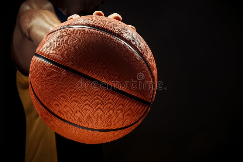 Vedere de siluetă a unui jucător de baschet care ține bila de baschet pe fond negru royalty free stock photos