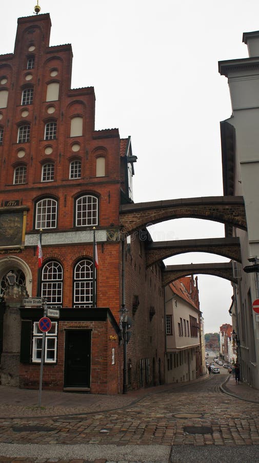 Vedere de stradă cu arcade de cărămidă și casă roșie frumoasă arhitectură Lubeck Germania stock photo