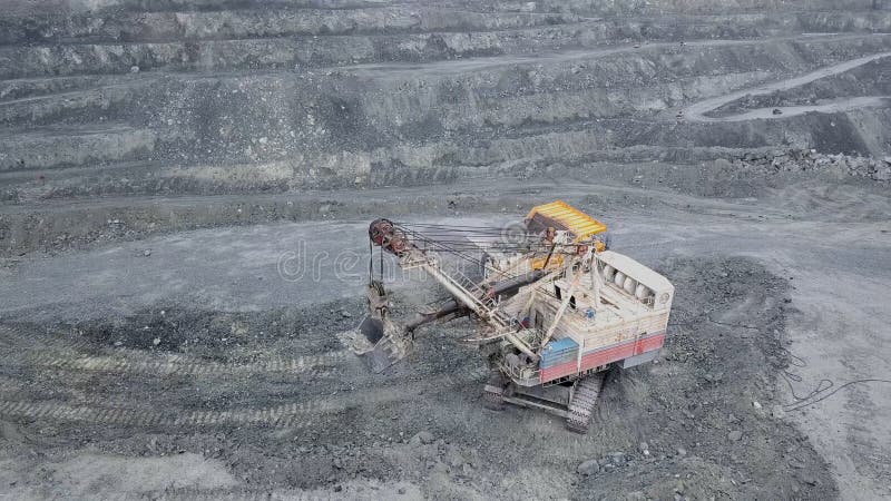Vedere de sus a excavatorului în groapă deschisă. excavator adoarme moloz în coșul de gunoi al carierei în aer liber în extracția stock image