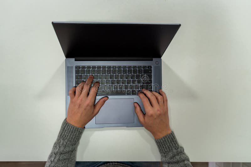 Vedere de sus a mâinilor masculi utilizând notebook-ul stock photography