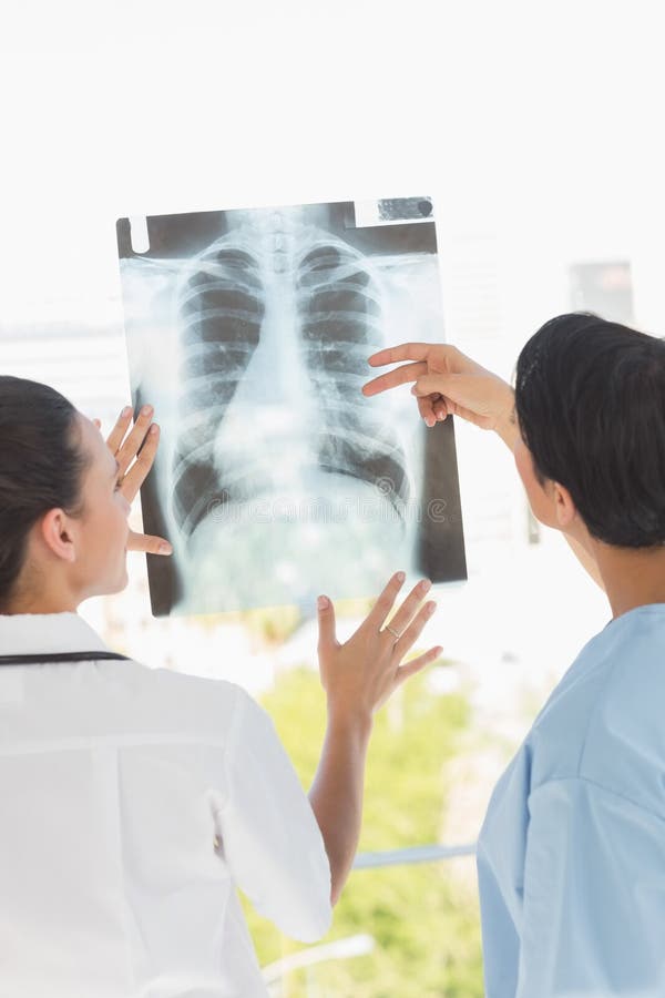 Vedere din spate a doi medici femei examinând xray royalty free stock images