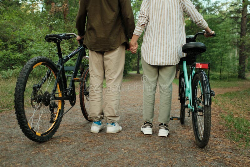 Vedere din spate a secțiunii joase a bicicliștilor tineri în ceea ce privește uzura în caz de accident pe șosea royalty free stock photo