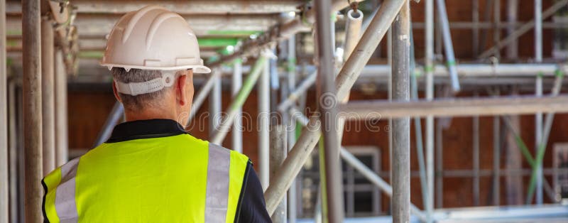 Vedere din spate a unui lucrător din construcții pe șantier royalty free stock images