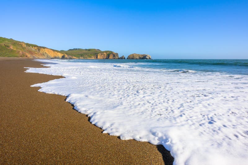 Vedere frumoasă asupra unui val și a unui țărm sălbatic al oceanului stock photography