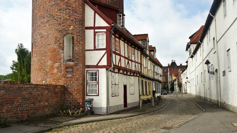 Vedere a zidului cărămizilor și a unei părți din Halbturmhaus, o casă pe jumătate pe stradă, o arhitectură frumoasă, Lubeck stock photography