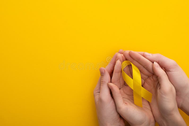 Veduta panoramica di donna e uomo con nastro giallo su fondo colorato concetto della Giornata internazionale del cancro dell'infan