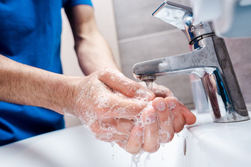 Veduta tagliata delle mani saponate lavate da un medico