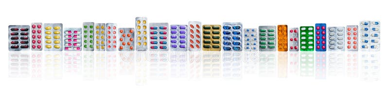 Veel van kleurrijke pillen in blaarpakken op een rij op witte achtergrond met exemplaarruimte De geneesmiddelenindustrie