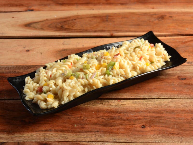 Veg Cheese Pasta Served in a Plate on a Rustic Wooden Table, Selective