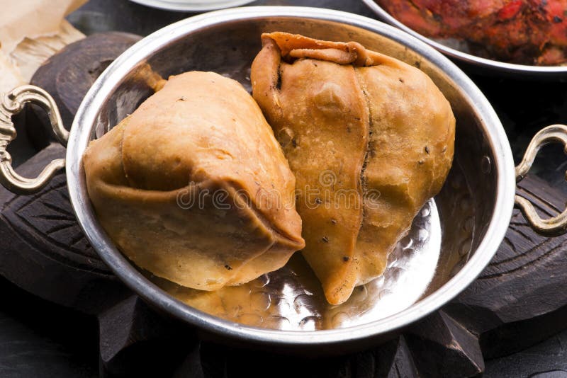 Veg Samosa is a Crispy and Spicy Indian Triangle Shape Snack Stock