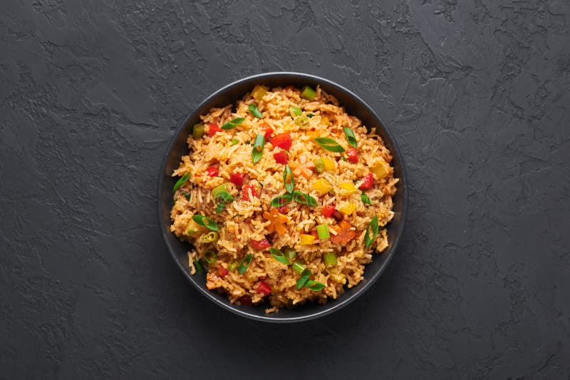 Veg Schezwan Fried Rice σε μαύρο μπολ σε σκούρο φόντο σχιστόλιθου πιάτο μαγειρικής ινδο-κινέζικα στοκ φωτογραφία
