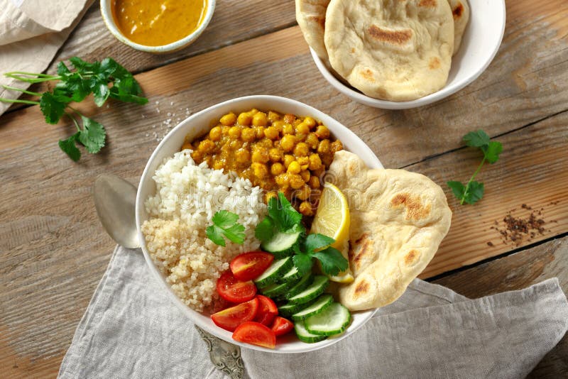 Vegan buddha bowl with naan bread on wooden table top view. Healthy vegetarian food concept. Vegan buddha bowl with naan bread on wooden table top view. Healthy vegetarian food concept