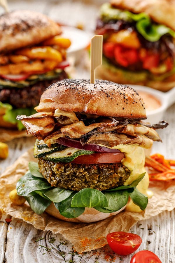 Vegan burger, green peas burger, homemade burger with green peas cutlet, grilled mushrooms, zucchini, tomato, red onion, lamb`s l stock images Vegan burger, green peas burger, homemade burger with green peas cutlet, grilled mushrooms, zucchini, tomato, red onion, lamb`s l stock images