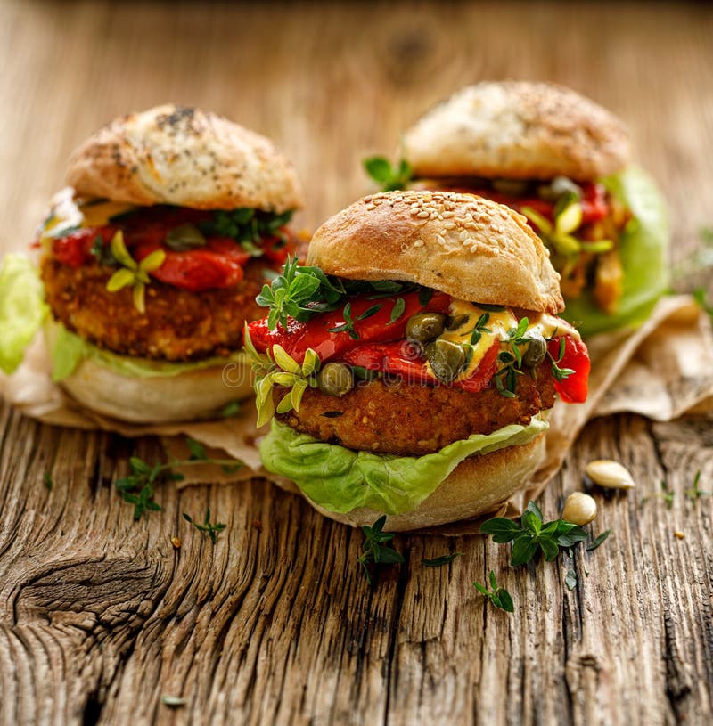 Vegan burgers, Pumpkin burgers with the addition of grilled peppers, lettuce, fresh herbs and capers on a wooden rustic table. Addition salad stock images, royalty-free photos and pictures