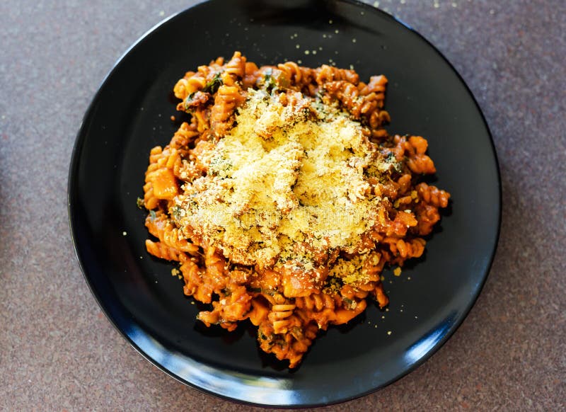 Healthy plnat-based recipes concept, fusilli pasta with lentils pumpkin cubes and kale topped with nutritional yeast. Healthy plnat-based recipes concept, fusilli pasta with lentils pumpkin cubes and kale topped with nutritional yeast