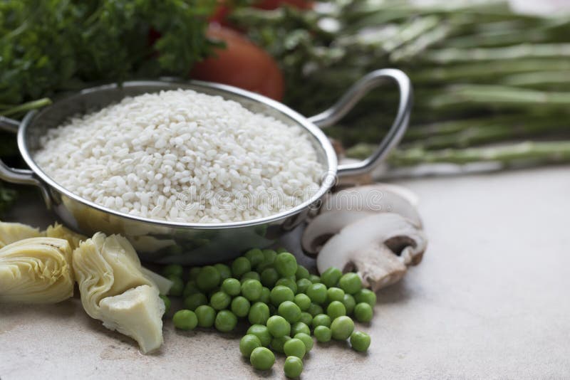 Rice, artichokes, peas, mushrooms and other ingredients for vegetarian paella. Rice, artichokes, peas, mushrooms and other ingredients for vegetarian paella