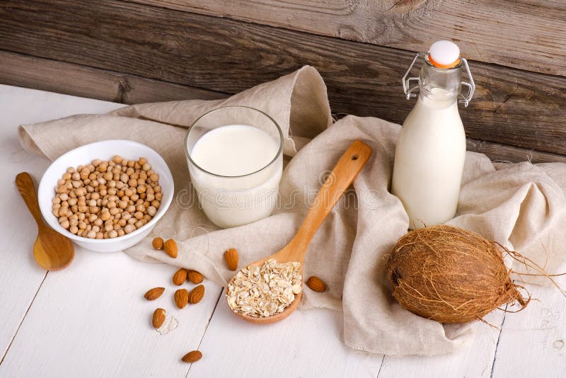 Vegan молоко молокозавода не в ингредиентах как гайка, миндалине альтернатив бутылки и молока, сое, овсе на деревянном столе с по стоковое изображение rf Vegan молоко молокозавода не в ингредиентах как гайка, миндалине альтернатив бутылки и молока, сое, овсе на деревянном столе с по стоковое изображение rf
