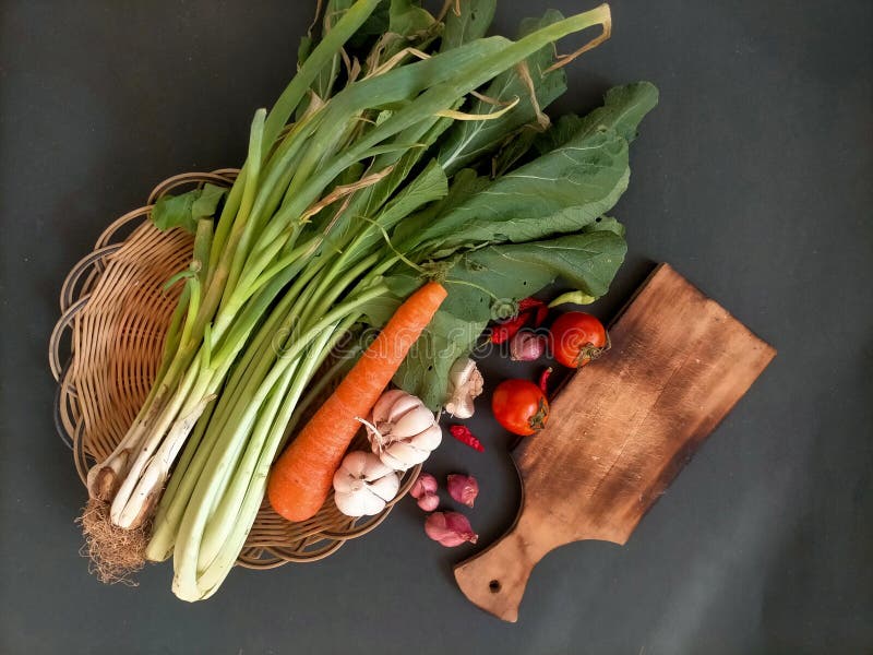 Vegetable on bamboo tray, wood cooking tool on black background stock photos.