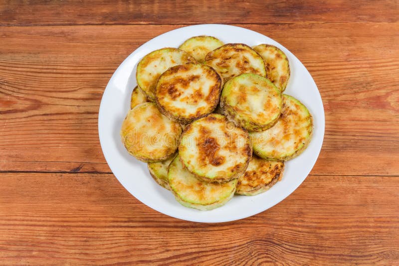 Vegetable Marrows Fried in Batter on Dish on Rustic Table Stock Photo