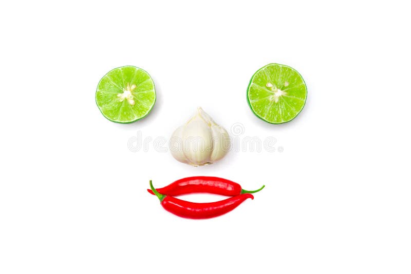 Vegetable smiling face from red chili pepper , garlic and lime on white background