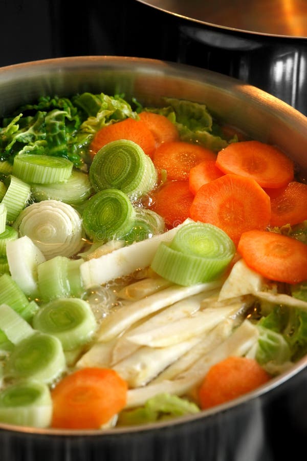 Ein brodelnder Topf Gemüse-Suppe auf dem Herd.