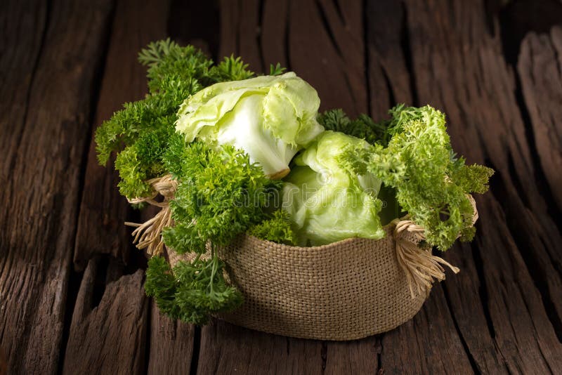 Vegetables in the basket on wooden background stock photos