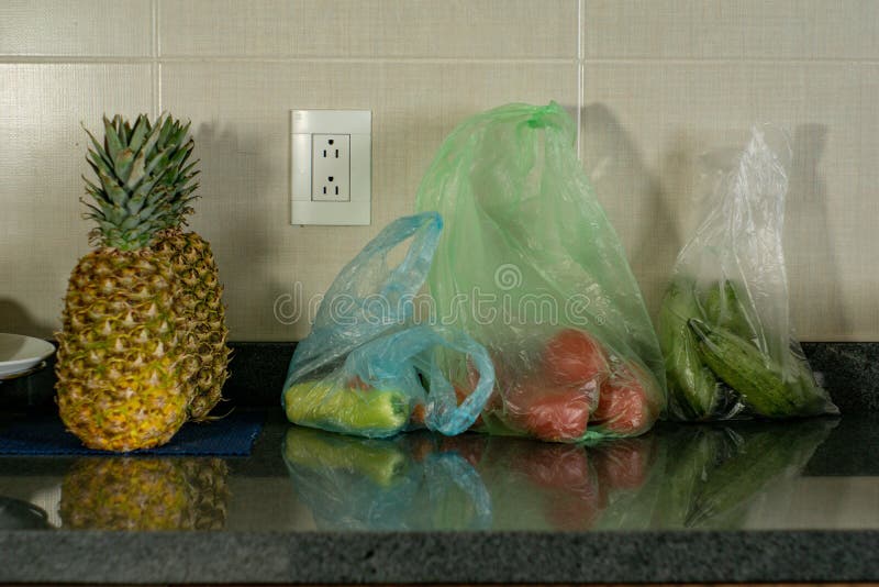 Vegetables and Fruits Inside Plastic Bags in the Kitchen Stock Photo