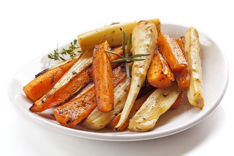 Vegetais de raiz Roasted no prato branco isolado imagem de stock Vegetais de raiz Roasted no prato branco isolado imagem de stock