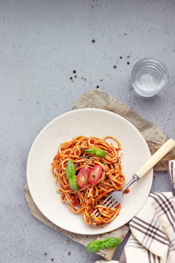 Vegetarian appetizing pasta served with tomato sauce, basil and fresh cherry tomatoes on ceramic plate. royalty free stock photography