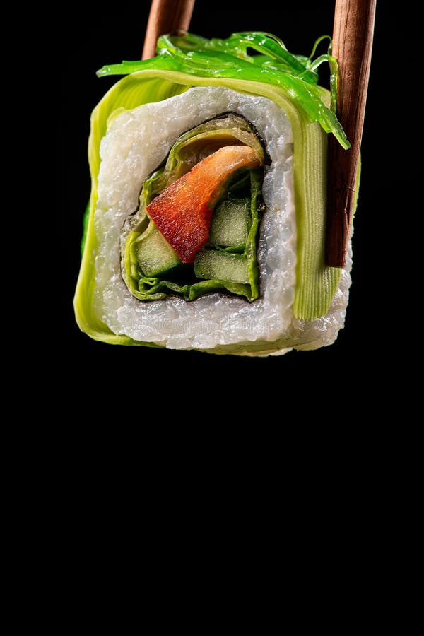 Vegetarian food concept. One sushi roll with papper, cucumber and cabbage, avocado